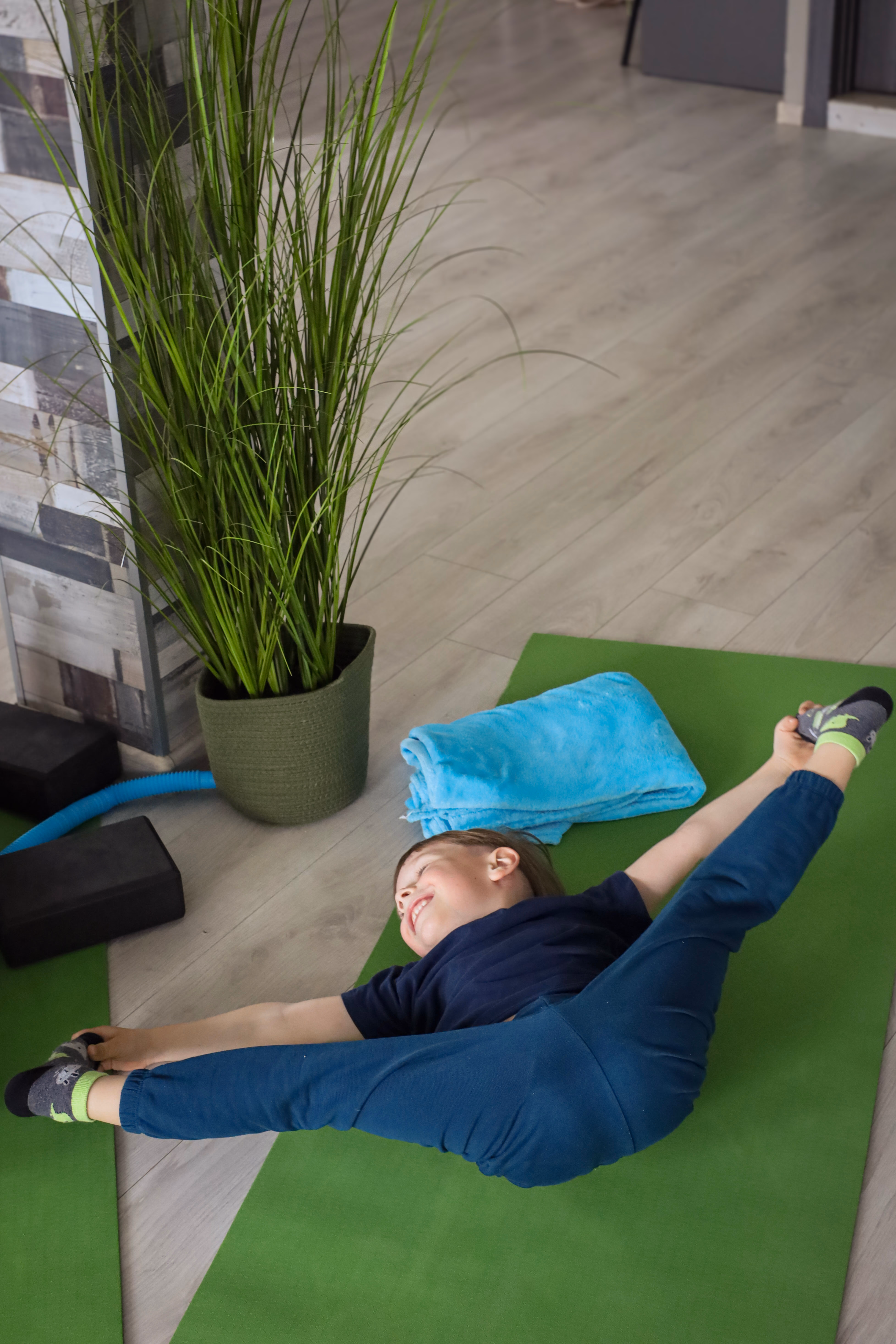 Дитина виконує розтяжку на йога-килимку