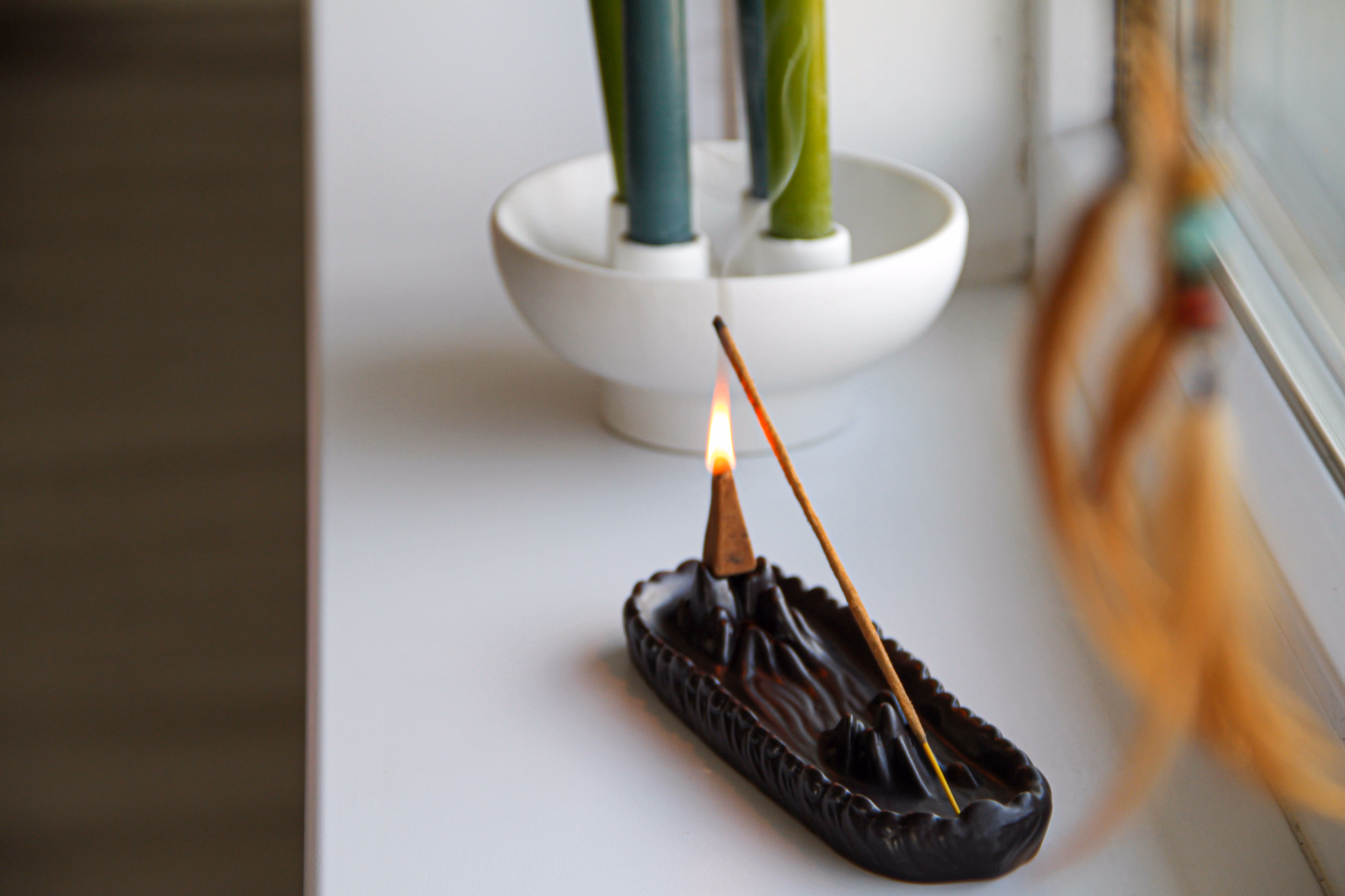 Ароматична паличка та свічки на підвіконні студії