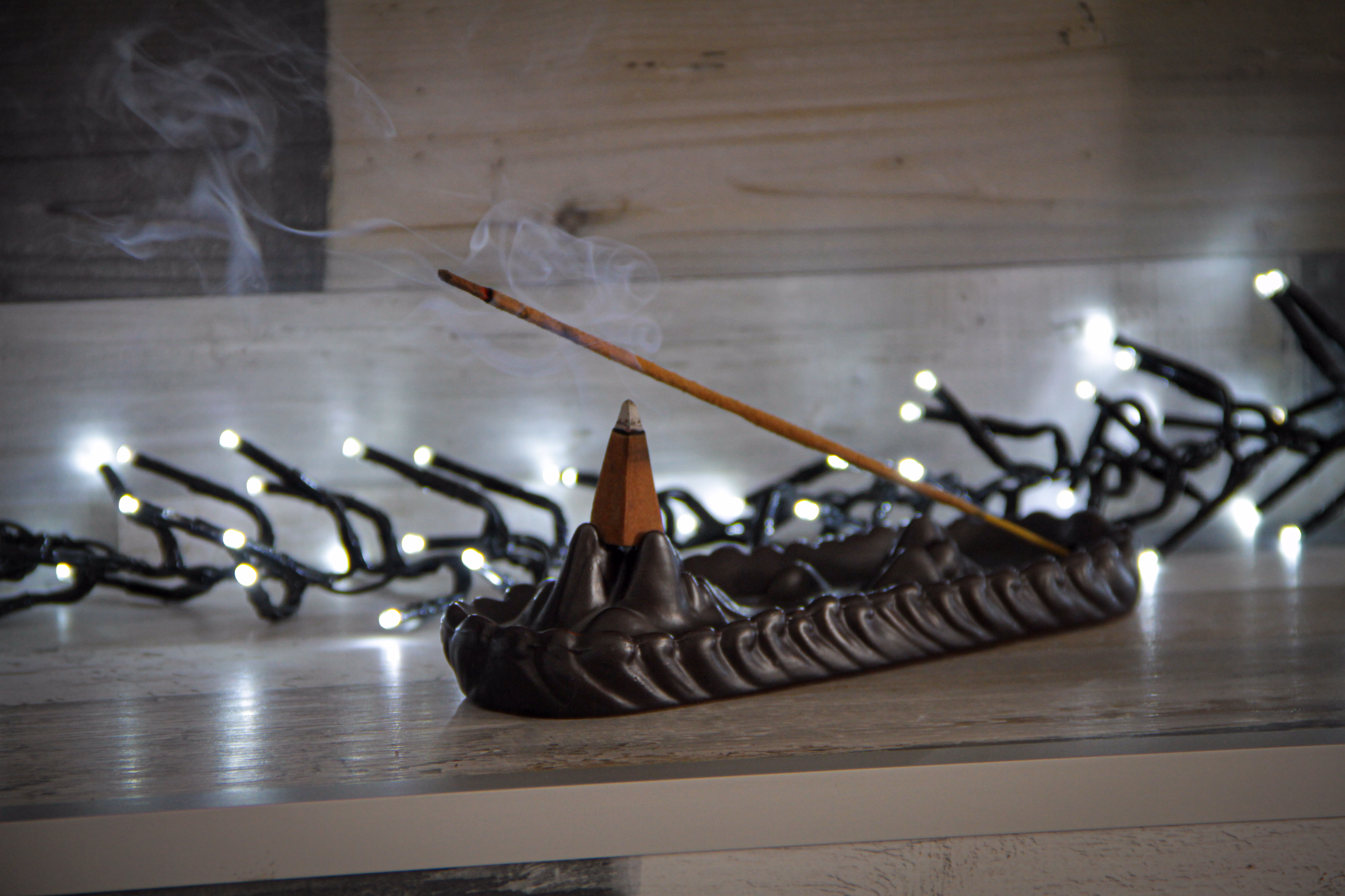 Підставка для пахощів з димком на тлі гірлянди